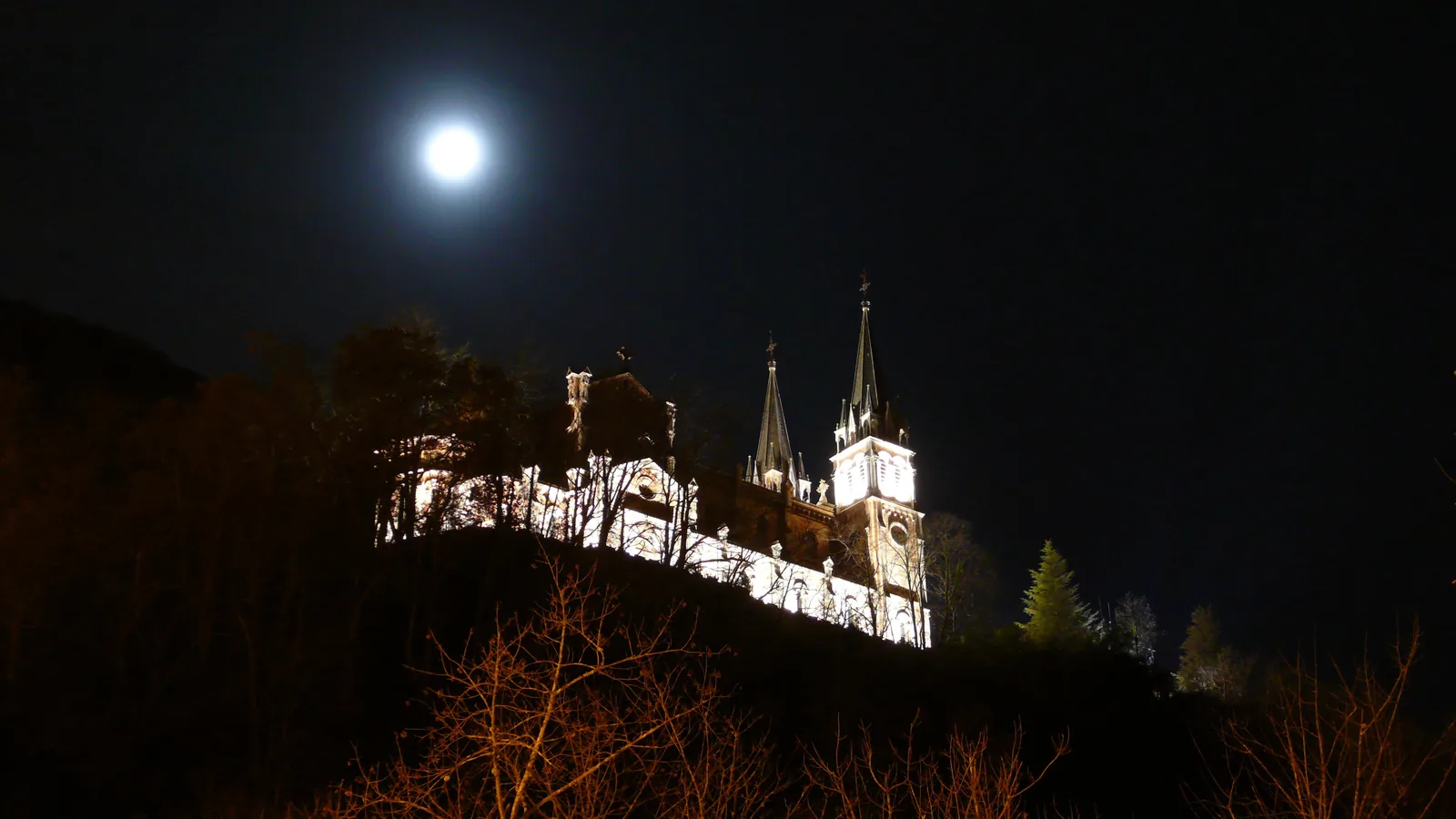 Santuario de Covadonga iluminado de noche bajo la luna
