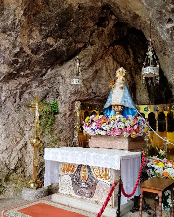 Imagen de la Virgen de Covadonga adornada con flores en la Santa Cueva